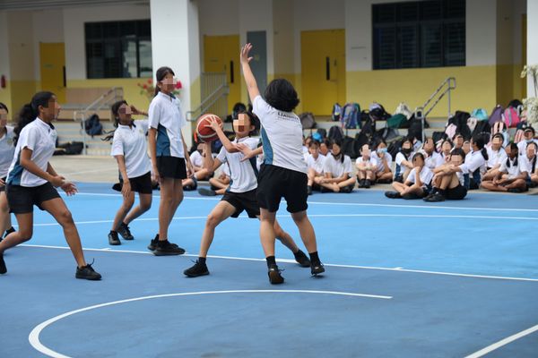 Primary school girls playing basketball during the Inter-Class Games at Lianhua Primary School, demonstrating teamwork and enthusiasm in a PE setting supported by the Mangostin App.